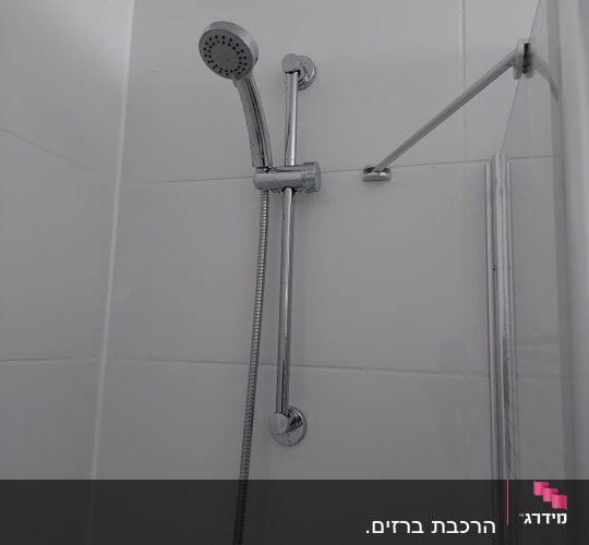 ראש מקלחת וכיור בחדר אמבטיה